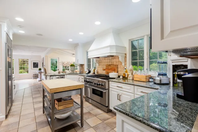 a kitchen with sink a stove and chairs