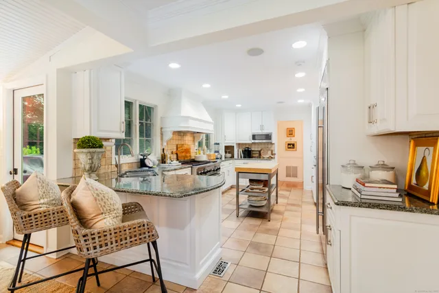 a kitchen with stainless steel appliances kitchen island granite countertop a sink and cabinets