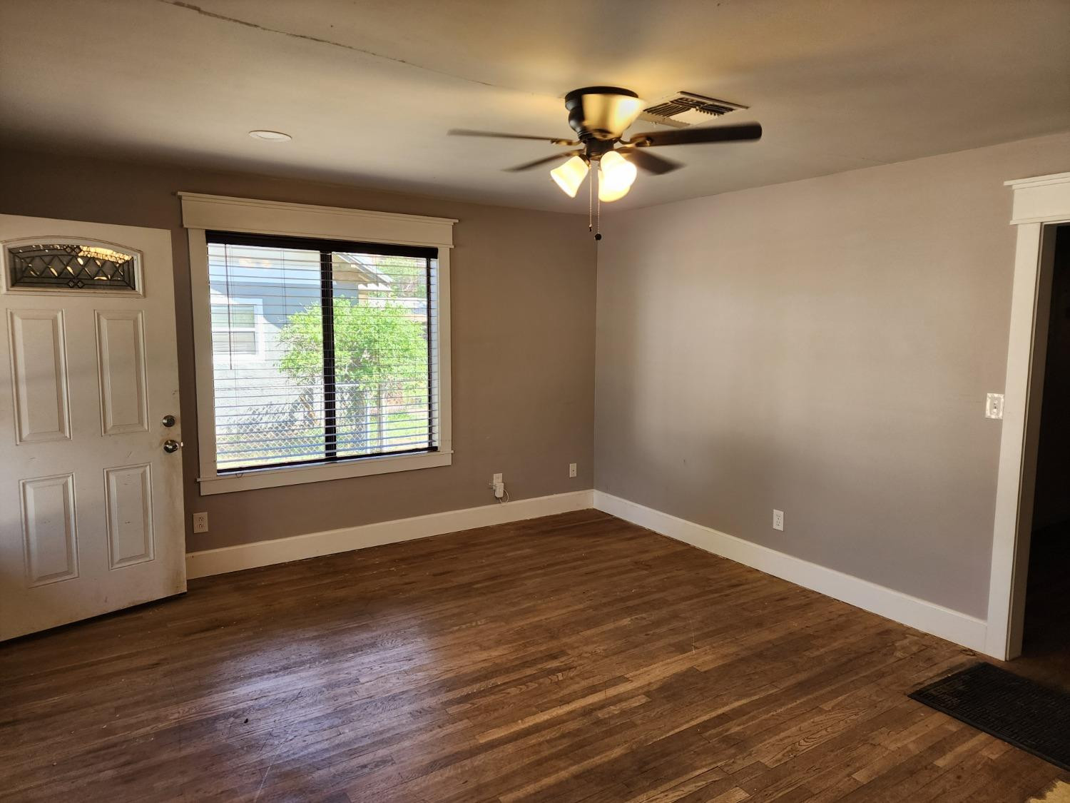 230 South 11th Street Slaton, TX 79364 - Photo 2 of 10 a view of empty room with wooden floor and fan
