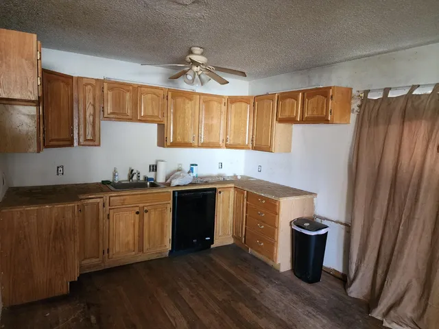 a kitchen with granite countertop a refrigerator and a sink