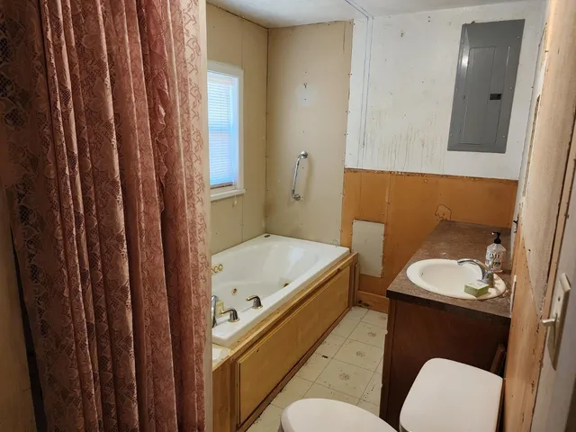 a bathroom with a toilet a sink and mirror