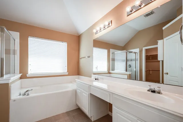 a bathroom with a large tub sink and mirror