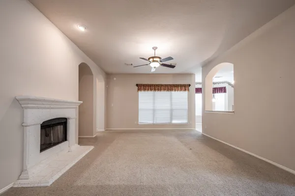 a view of an empty room with a fireplace and a window
