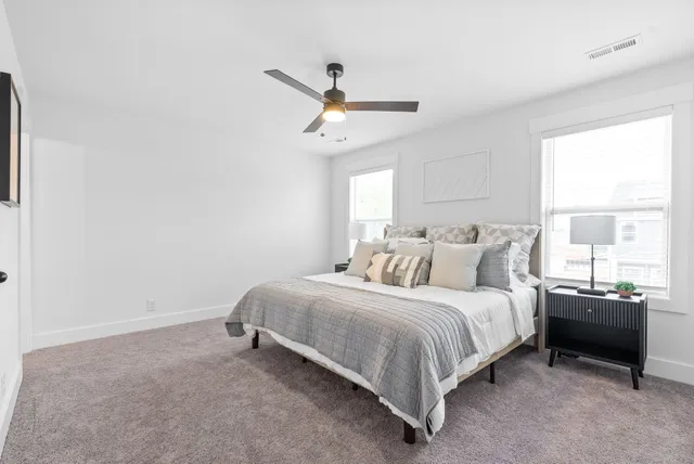 a bedroom with a bed and painting on the wall