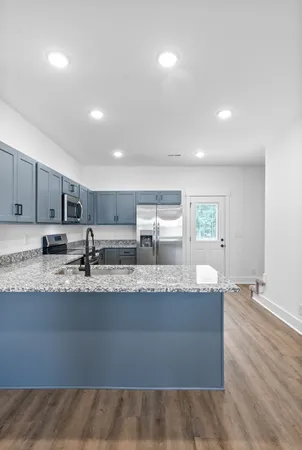 a kitchen with stainless steel appliances granite countertop a refrigerator a sink a stove a microwave and island