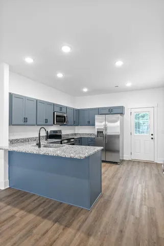 a kitchen with granite countertop a sink and a large mirror