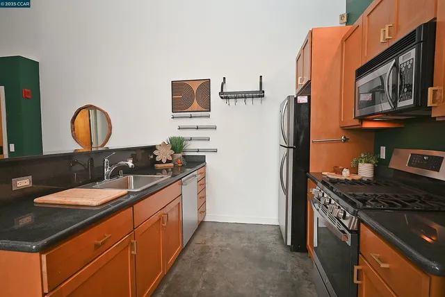 a kitchen with stainless steel appliances granite countertop a sink stove and refrigerator