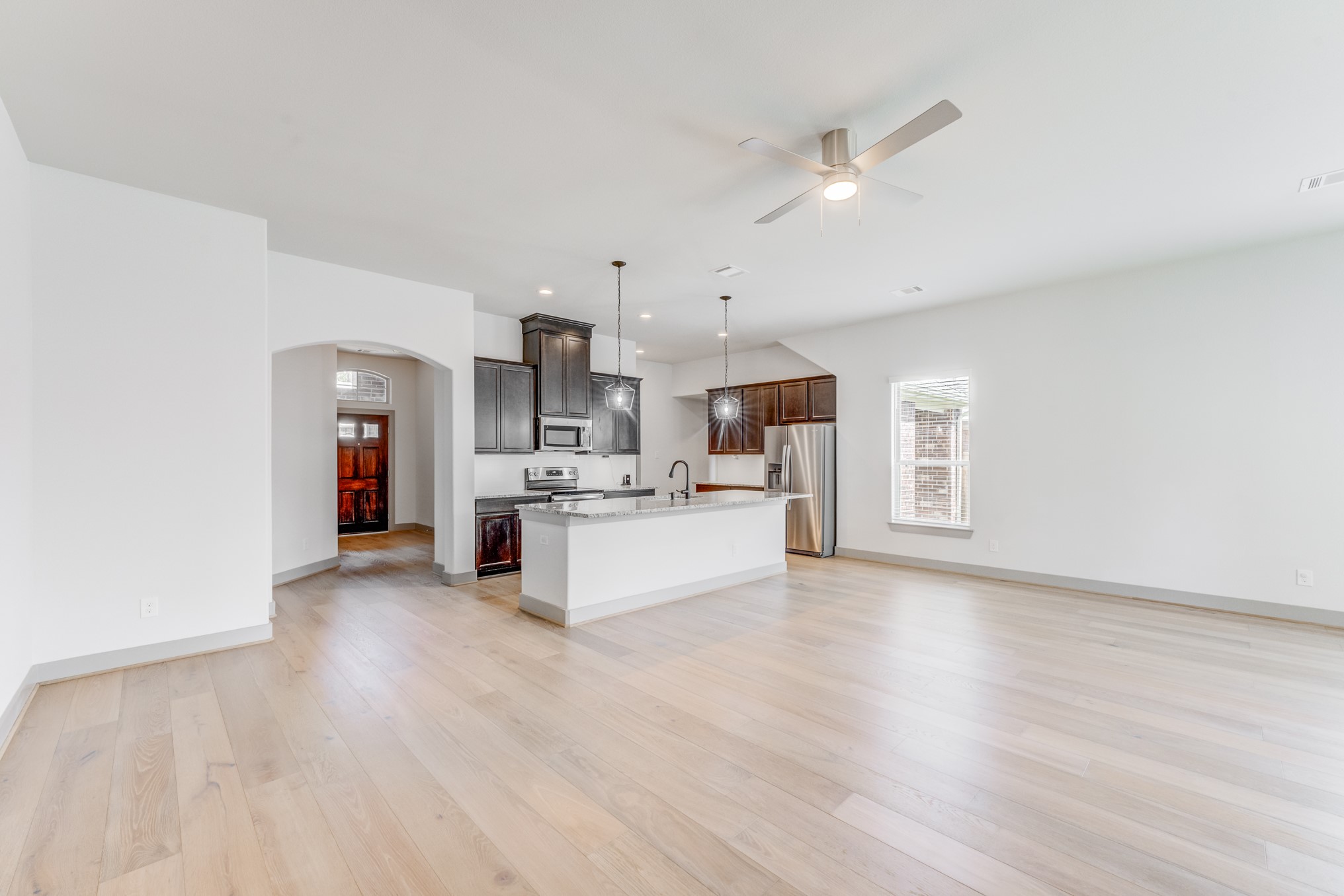 11913 Mockingbird Lane Montgomery, TX 77356 - Photo 16 of 19 a large white kitchen with kitchen island a stove a sink dishwasher and a fireplace with wooden floor