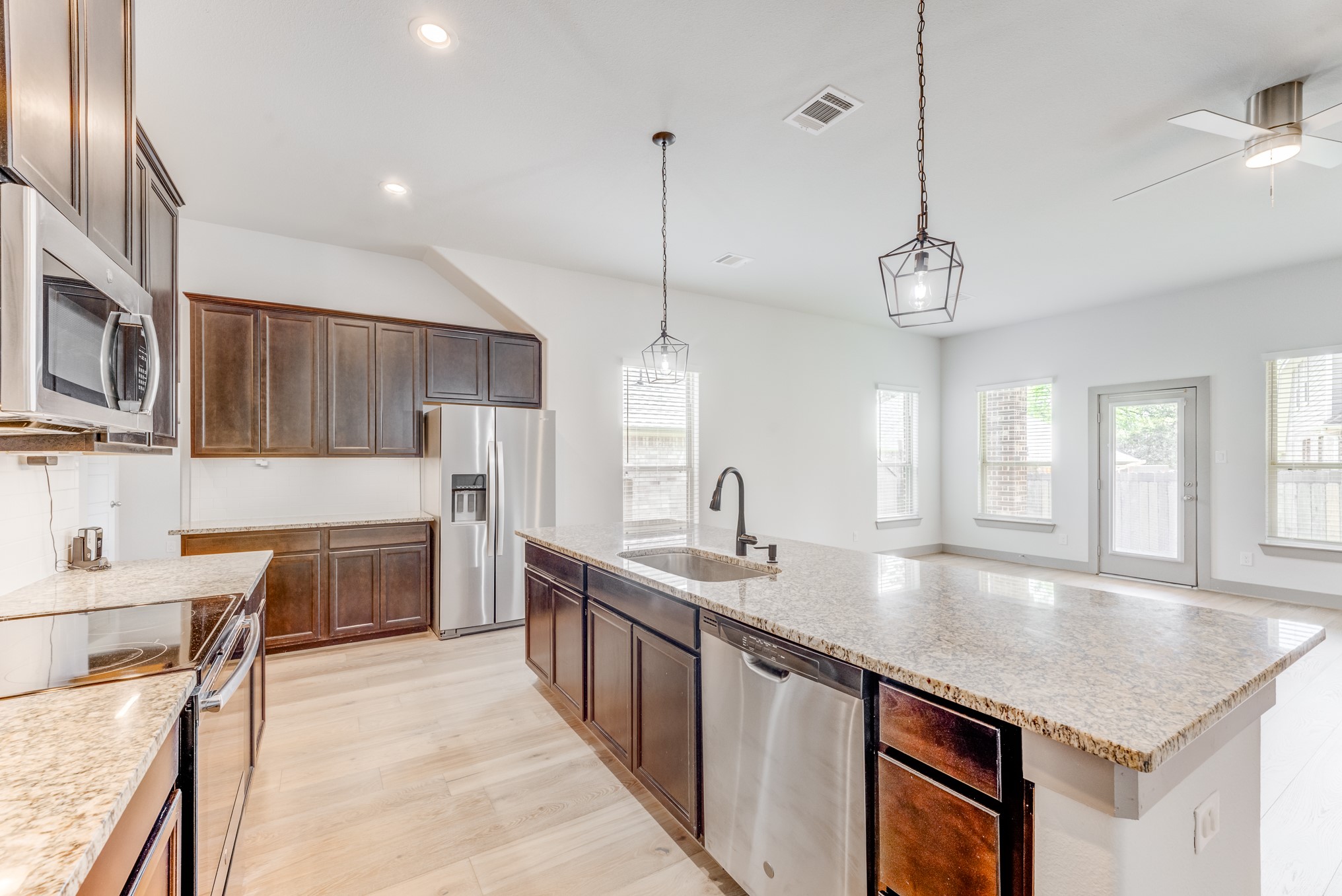 11913 Mockingbird Lane Montgomery, TX 77356 - Photo 3 of 19 a kitchen with stainless steel appliances granite countertop a sink a stove and a wooden floors