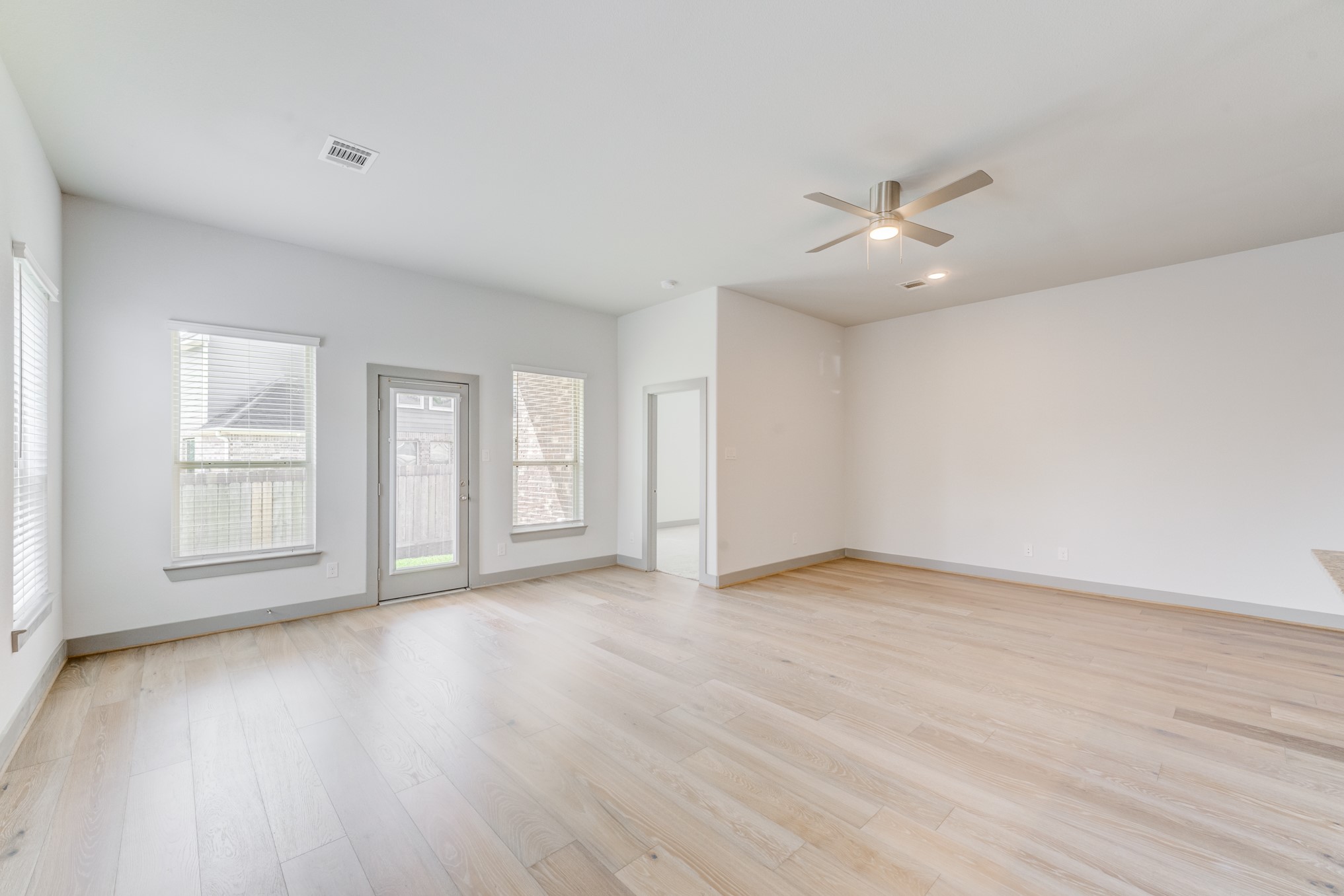 11913 Mockingbird Lane Montgomery, TX 77356 - Photo 7 of 19 an empty room with wooden floor chandelier fan and windows