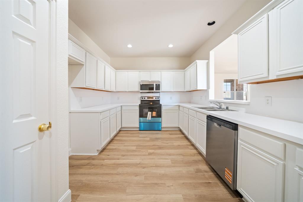 908 West Wintergreen Road Lancaster, TX 75134 - Photo 14 of 38 a kitchen with granite countertop white cabinets and white appliances