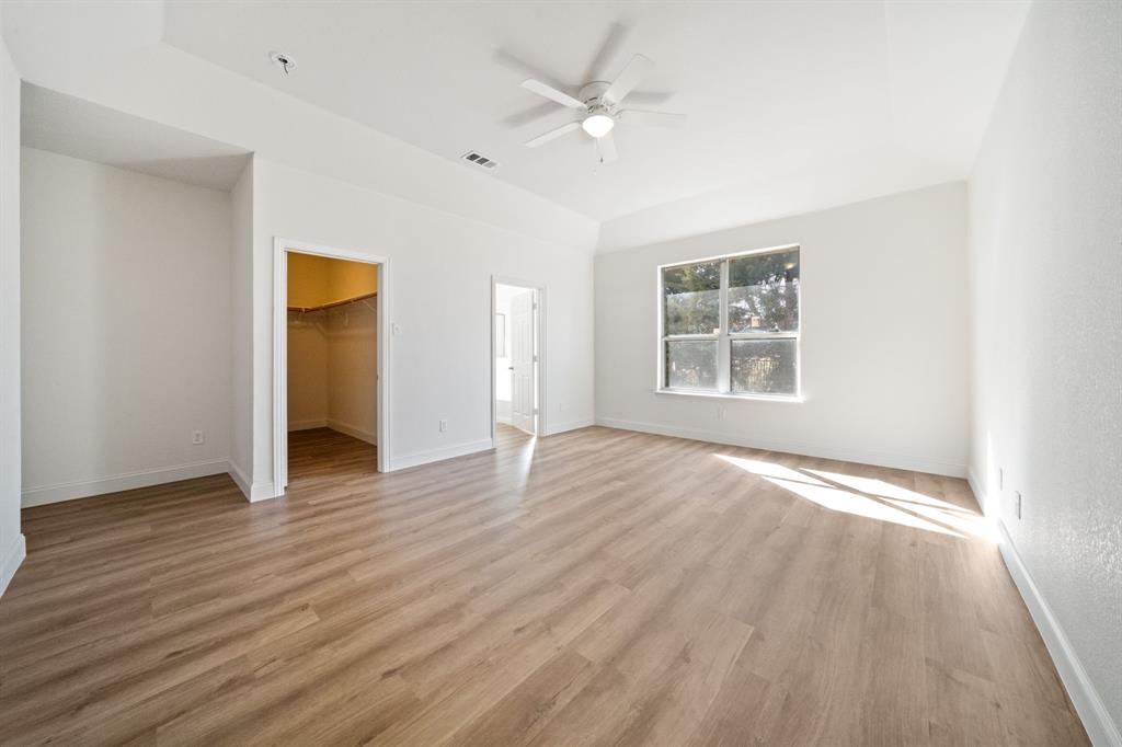 908 West Wintergreen Road Lancaster, TX 75134 - Photo 23 of 38 an empty room with wooden floor ceiling fan and windows