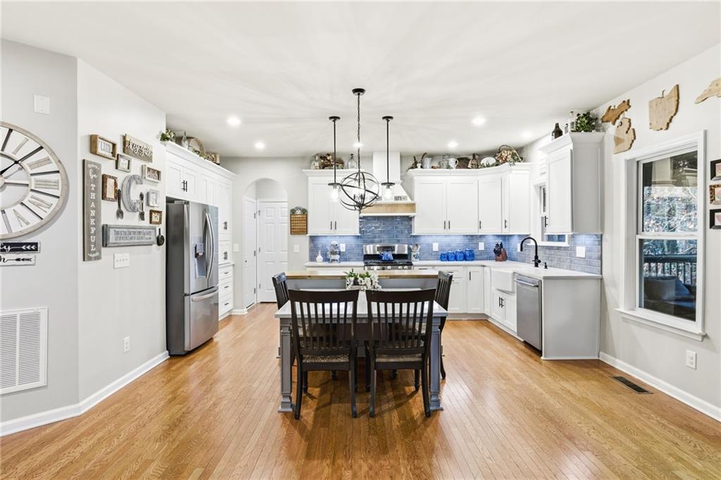 1122 Flagstone Way Acworth, GA 30101 - Photo 14 of 49 a kitchen with stainless steel appliances kitchen island granite countertop a refrigerator a stove a sink dishwasher and a dining table with wooden floor