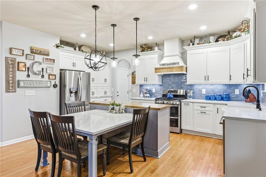 1122 Flagstone Way Acworth, GA 30101 - Photo 16 of 49 a kitchen with stainless steel appliances kitchen island granite countertop a table chairs and white cabinets