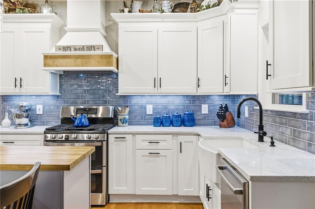 1122 Flagstone Way Acworth, GA 30101 - Photo 18 of 50 a kitchen with granite countertop a sink a stove and cabinets