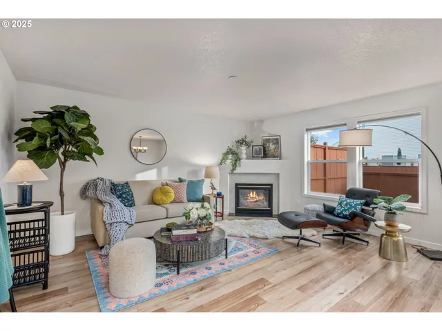 a living room with furniture a fireplace and potted plants