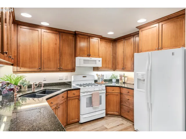 a kitchen with a white appliances a sink and cabinets