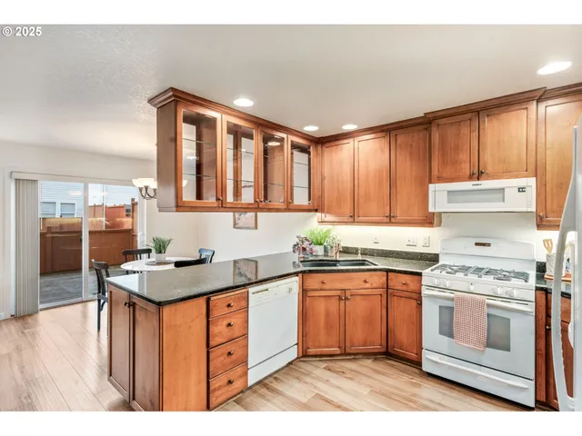 a kitchen with stainless steel appliances granite countertop a stove a sink dishwasher and a refrigerator