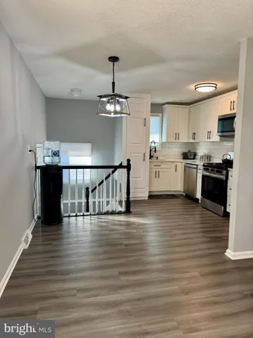 a large kitchen with stainless steel appliances granite countertop a stove and cabinets
