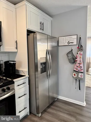 a kitchen with stainless steel appliances granite countertop a refrigerator and a stove