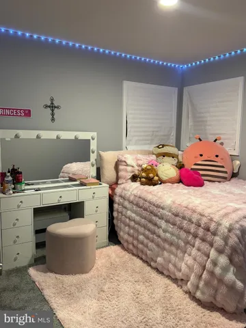 a bed sitting in a bedroom next to a window and a curtain