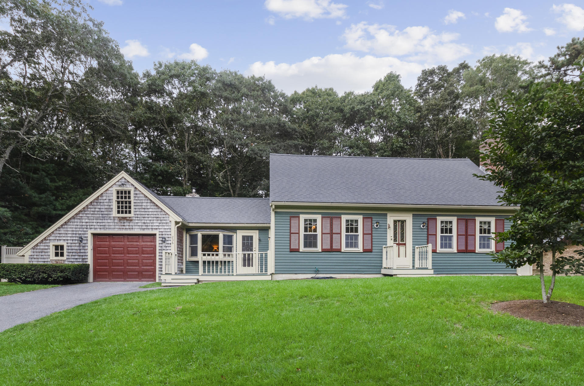 236 Old Mill Road Marstons Mills, MA 02648 - Photo 1 of 20 a view of a yard in front of a house with large windows