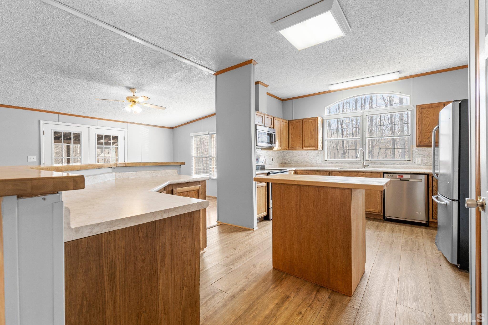 199 New Chestnut Drive Rougemont, NC 27572 - Photo 7 of 28 a kitchen with stainless steel appliances granite countertop a refrigerator a sink dishwasher a stove with wooden floor and cabinets