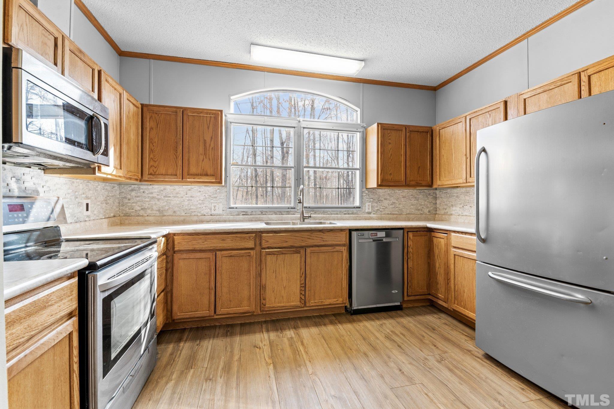 199 New Chestnut Drive Rougemont, NC 27572 - Photo 8 of 28 a kitchen with granite countertop a refrigerator a sink and wooden floors