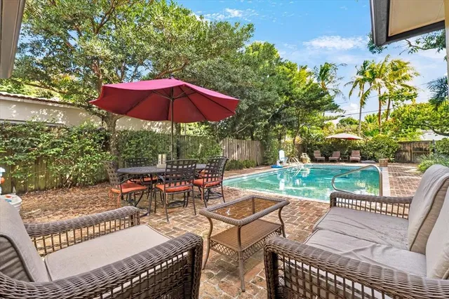 an outdoor sitting area with furniture and umbrella