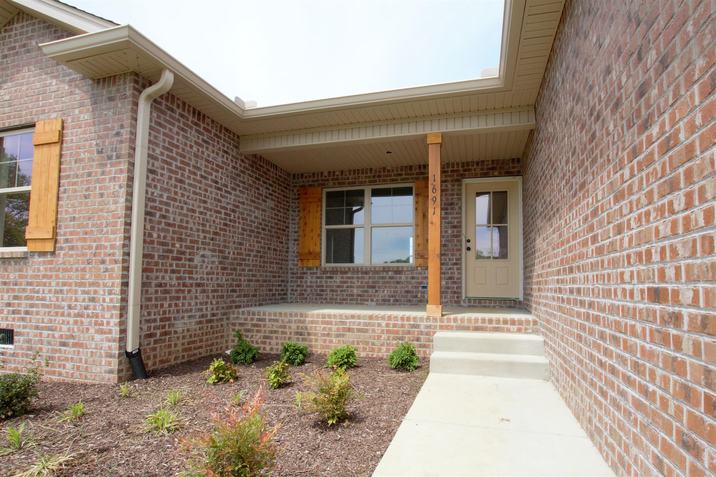1691 Rapids Road Portland, TN 37148 - Photo 3 of 6 a view of a brick house with potted plants