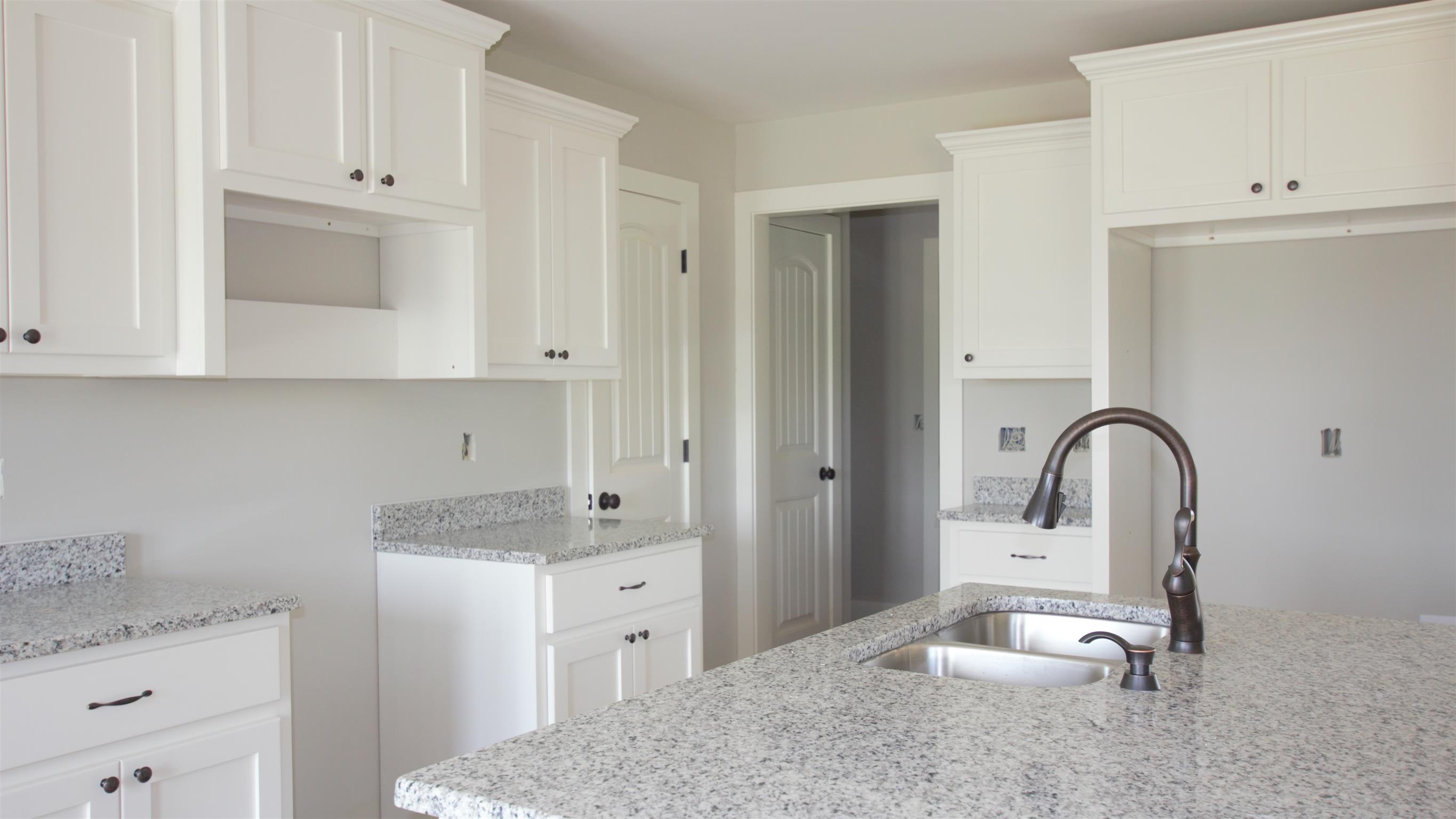 1691 Rapids Road Portland, TN 37148 - Photo 5 of 6 a kitchen with granite countertop white cabinets and a sink