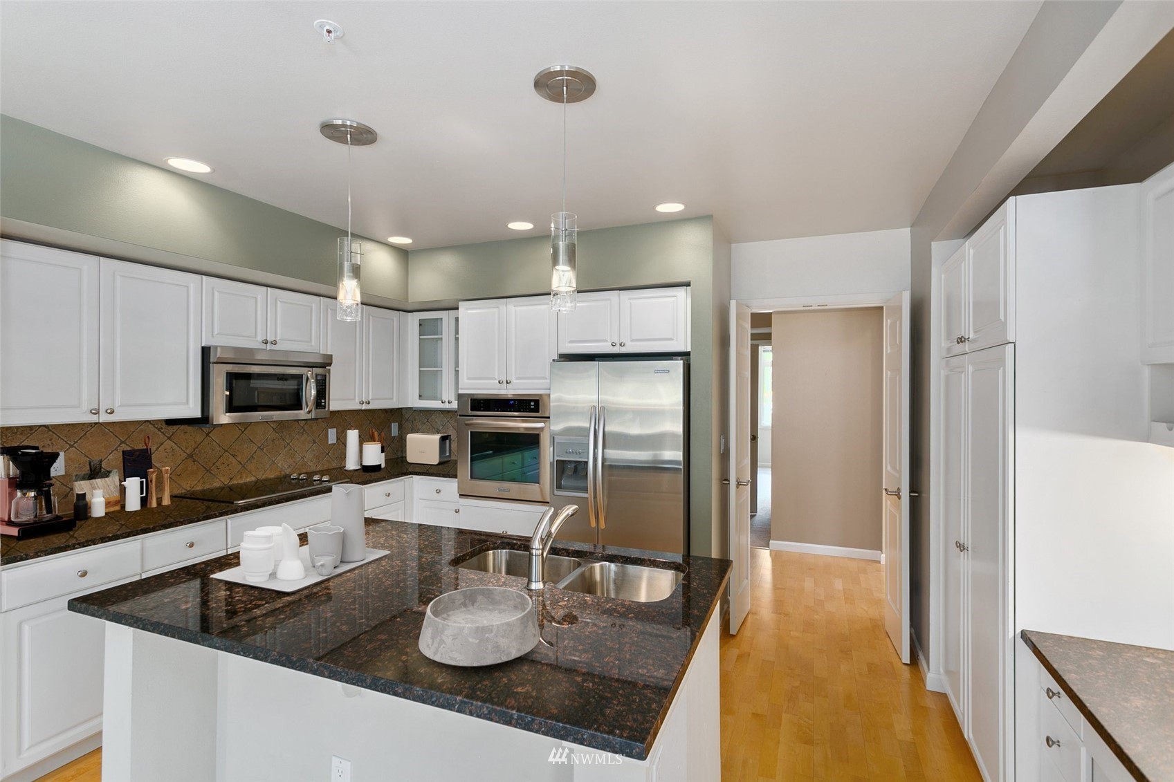 102 State Street, Unit 101W Kirkland, WA 98033 - Photo 13 of 38 a kitchen with stainless steel appliances granite countertop a sink refrigerator and microwave