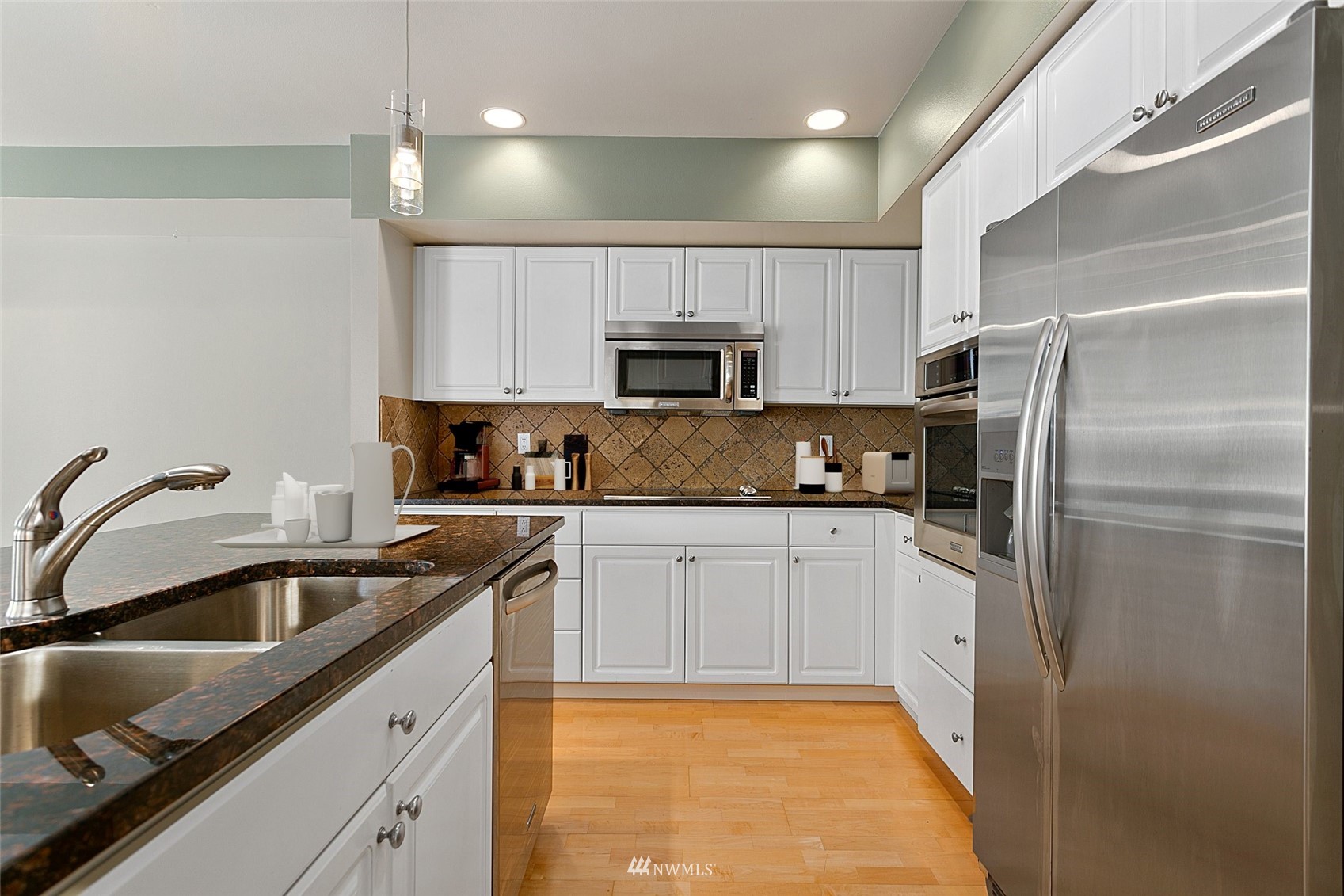 102 State Street, Unit 101W Kirkland, WA 98033 - Photo 14 of 38 a kitchen with a sink a refrigerator and cabinets