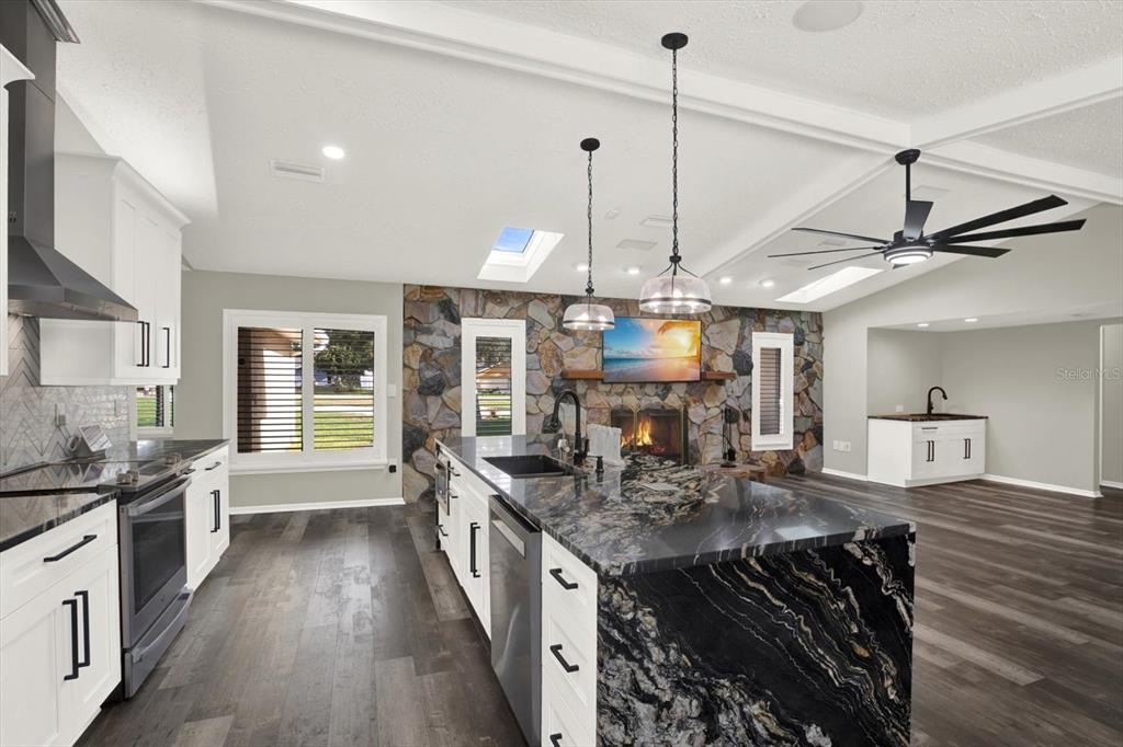 7487 River Country Drive Weeki Wachee, FL 34607 - Photo 18 of 53 a kitchen with stainless steel appliances granite countertop a stove a sink and a wooden floors