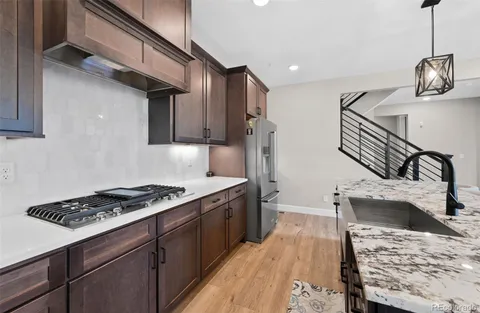 a kitchen with stainless steel appliances granite countertop a sink stove and refrigerator