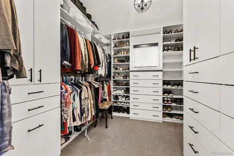 a view of walk in closet with clothes and shoes