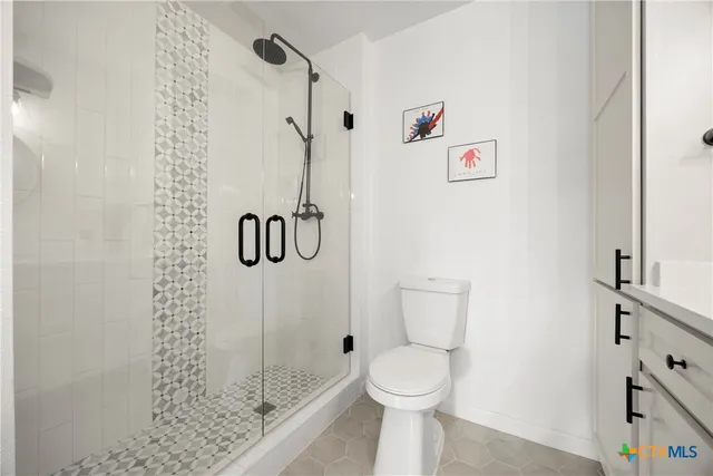 a bathroom with a shower a toilet and a shower