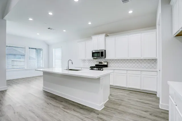 a kitchen with white cabinets stainless steel appliances and sink