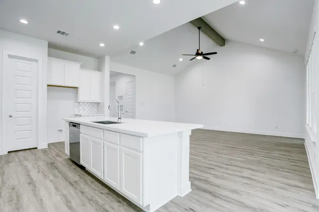 a kitchen with a sink cabinets and wooden floor