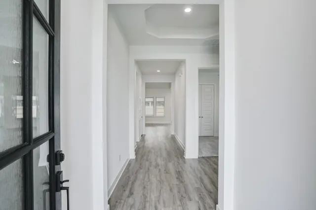 a view of a hallway with wooden floor and closet