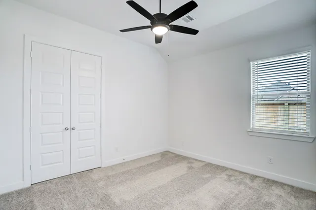 an empty room with a window and a fan