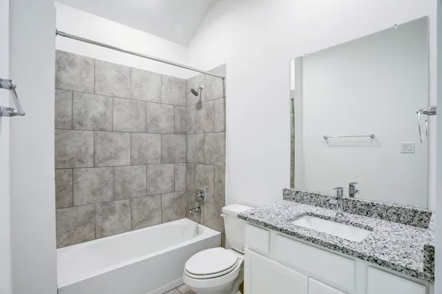 a bathroom with a granite countertop toilet a sink and bathtub