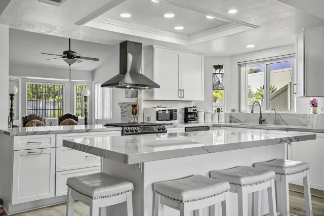 a kitchen with stainless steel appliances granite countertop a sink a stove and a refrigerator