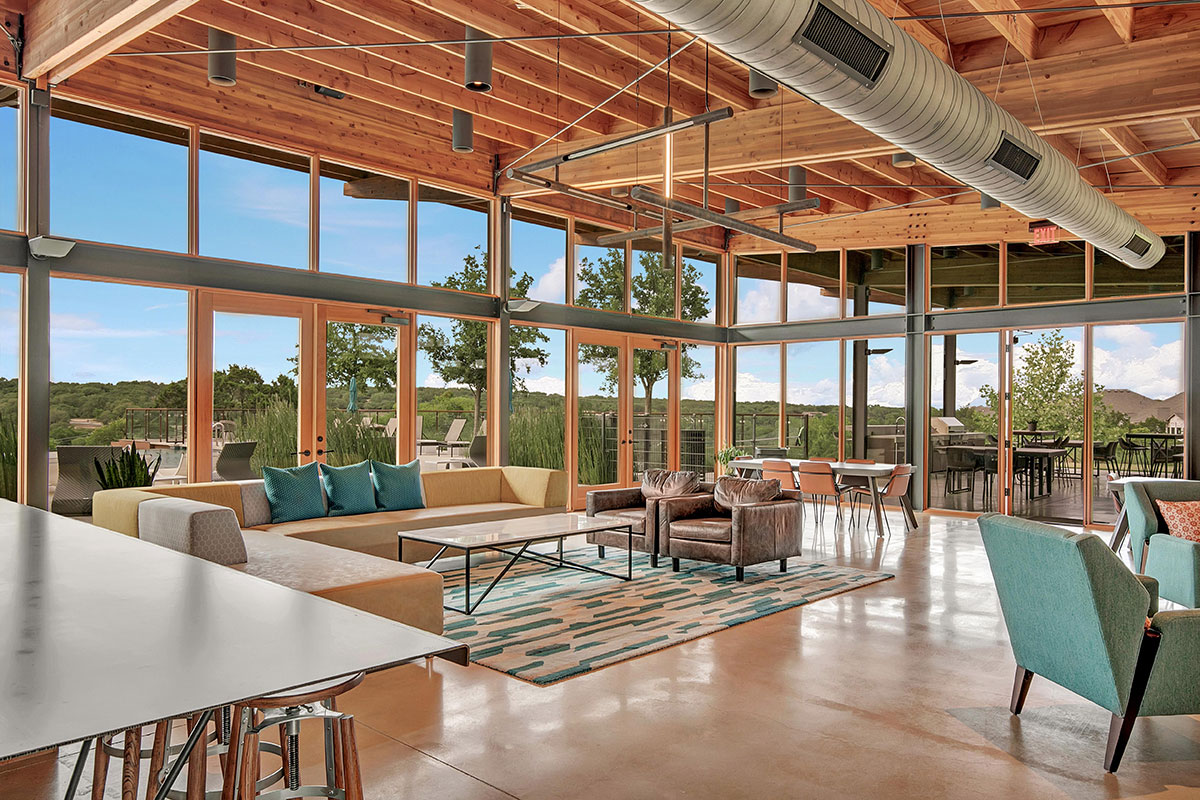 228 Arrowhead Mound Road Georgetown, TX 78628 - Photo 34 of 34 An airy lounge area with high ceilings and vast windows offers serene views of the surrounding landscape.