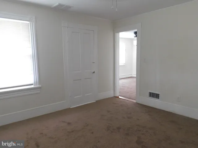 an empty room with windows and closet