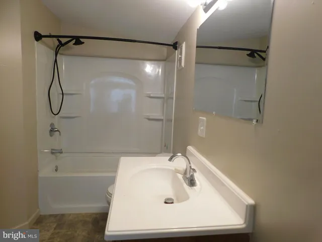 a bathroom with a white bath tub sitting next to a white sink and vanity