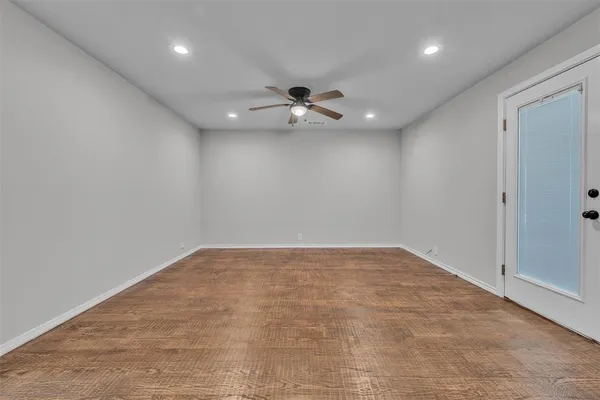 an empty room with a ceiling fan and a window