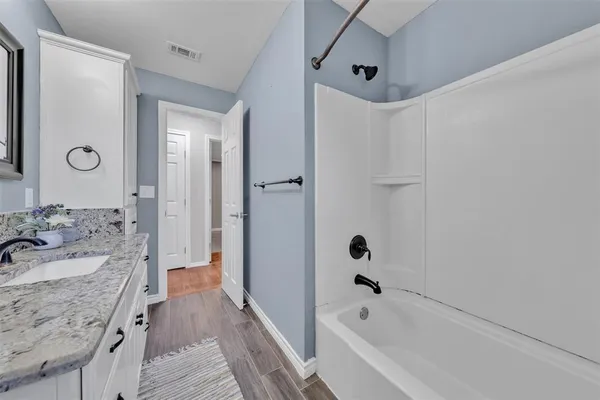 a bathroom with a tub sink and mirror