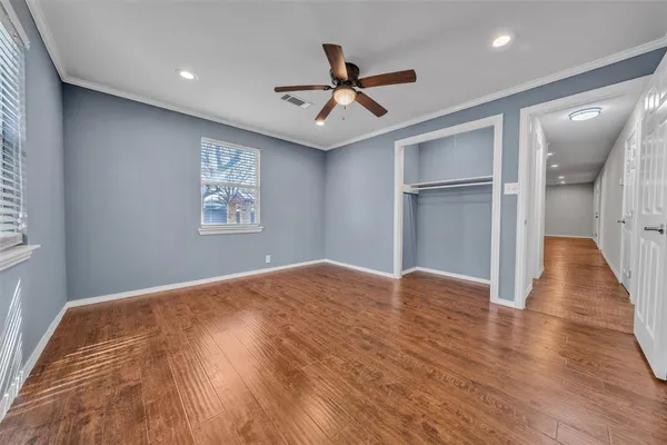 a view of empty room with wooden floor