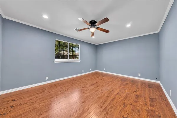 a view of a big room with wooden floor and windows